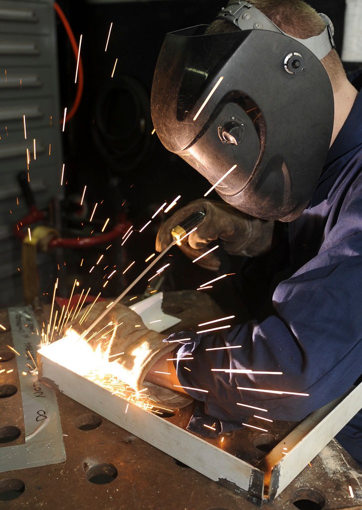 Técnico realizando soldadura de precisión, servicio de reparación de compresores